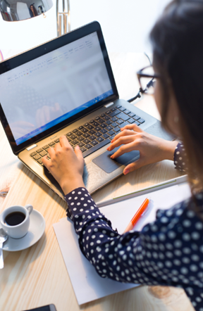 A woman types on a laptop